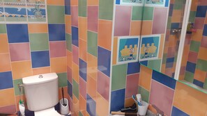 A bathroom with colorful tiles, a toilet, a bidet, and a hand dryer. - Beautiful 3-bedroom apartment (70 square meters) in Juan (Antibes)