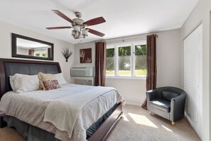 A bedroom with a bed, a ceiling fan, a window with curtains, an air conditioner, and a chair. - Poolside condo by Lake - walk up to Ridge Resort (Lake Geneva)
