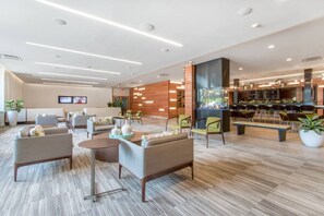 A modern hotel lobby with seating areas, a reception desk, and a bar/lounge area. - Cottage Condo by Lake, Pool & Ridge Resort (Lake Geneva)