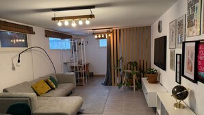 Een moderne woonkamer met een bank, een bureau en een boekenkast.