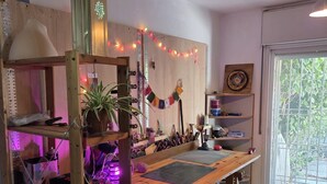 Ein Workshop mit einem langen Tisch, Hocker, Regalen und einem Fenster mit Blick.