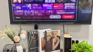 Un téléviseur à écran plat affichant l’interface d’un service de diffusion en continu, avec une section intitulée « Ce qui est tendance » et une section intitulée « Offres d’abonnement ».