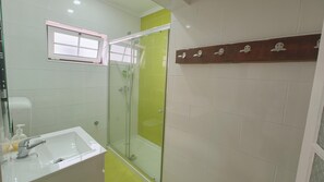 A bathroom with a glass shower enclosure, a sink with a soap dispenser, and a window. - Rustic house featuring traditional Portuguese handicrafts (Nazaré)
