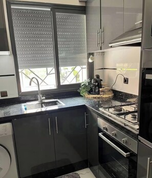 Een moderne keuken met een spoelbak, fornuis en kasten.