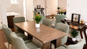 A dining area with a wooden table, six chairs, and a rug.