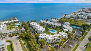 Ein Luftbild eines Resorts mit mehreren Gebäuden, einem Schwimmbad und einem Strand.