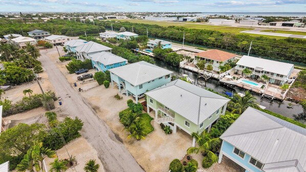 Vista aérea de una zona residencial con casas, una carretera y una masa de agua.