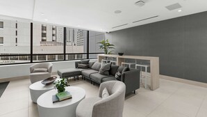 Una sala de estar moderna con un sofá modular, dos sillones, una mesa de centro y una planta.