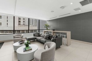 Ein modernes Wohnzimmer mit einem Ecksofa, zwei Sesseln, einem Couchtisch und einer Pflanze.