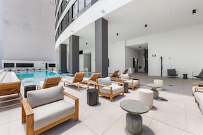 Eine Dachterrasse mit Pool, Liegestühlen und Tischen.