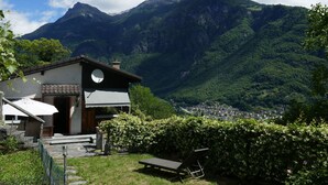 Une propriété située en montagne, avec une petite construction, une terrasse et une vue sur une vallée.