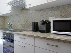 A kitchen with a microwave, coffee maker, and stove. - Lodrino Canyoning by Interhome (Lodrino)