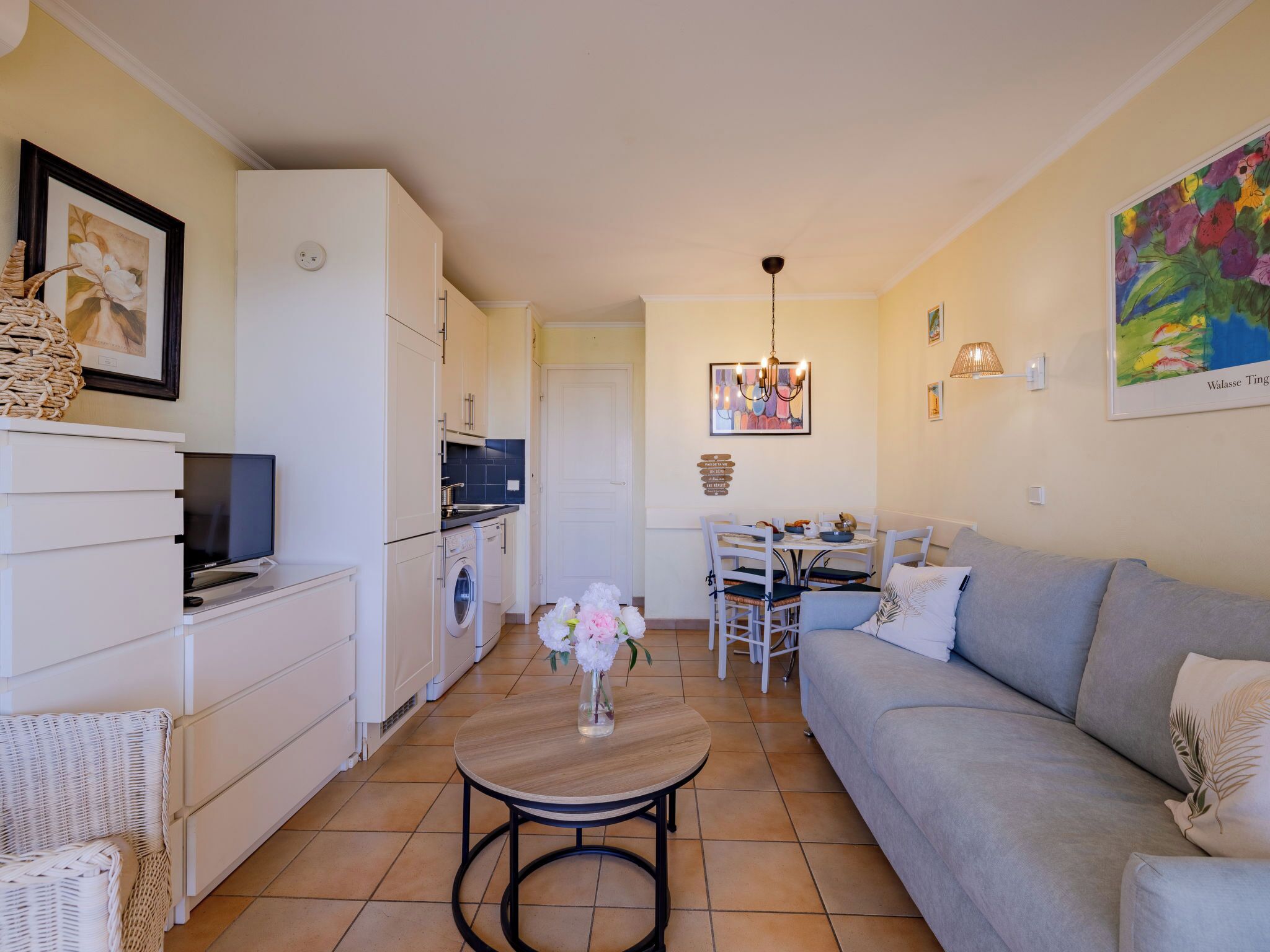 A compact living space with a kitchenette, a dining area, and a sofa.