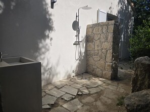 A stone-walled outdoor shower area with a built-in sink, surrounded by stone paving and greenery. - Villa renovated Swimming pool - 4 bdrms -Sant'Ambroggio (Lumio)