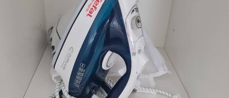 An iron with a cord, placed on a white surface.