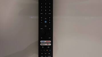 A black remote control with a numeric keypad, directional pad, and various function buttons including volume and power.