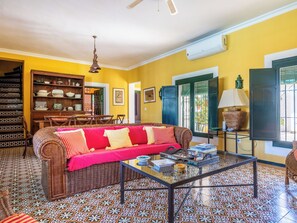 Uma sala de estar com sofá, mesa de centro e ladrilhos estampados.
