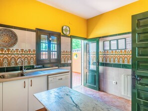 Una cocina con encimera de mármol, lavavajillas Bosch y puerta verde.