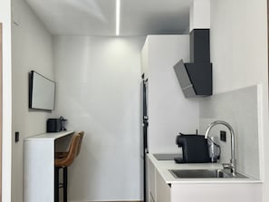 A compact kitchen with a sink, a coffee maker, and a chair. - Flower Beach Helgueras 5 - 6095 (Noja)