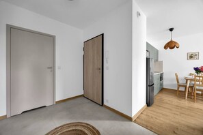 Eine moderne Küche mit Kühlschrank, Herd und Esstisch mit Stühlen.