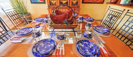 A dining table set with blue plates, red napkins, and silverware, surrounded by chairs.