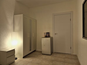 Un couloir avec un bureau, une armoire et une porte.