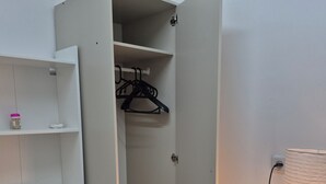 Et værelse med et klædeskab, en skraldespand og en lampe.