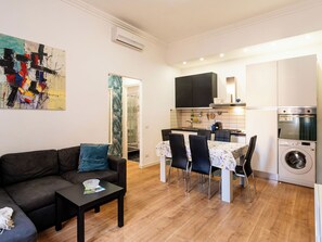 Een moderne woonkamer met een bank, salontafel en een schilderij aan de muur.