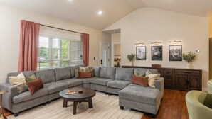 A living room with a sectional sofa, a coffee table, and a cabinet.