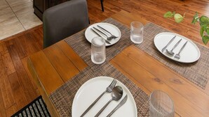 A modern kitchen with a dining area, a gray sofa, and a large window. - Bourbon Trailhead Bardstown (Bardstown)