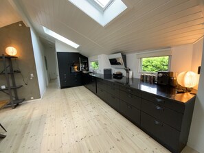 Eine moderne Küche mit Oberlichter, dunklen Schränken und Holzboden.