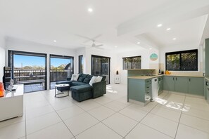 Eine moderne Wohnung mit Wohnbereich, Küche und Balkon.