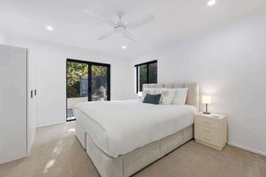 Ein Schlafzimmer mit Bett, Nachttisch und Deckenventilator.
