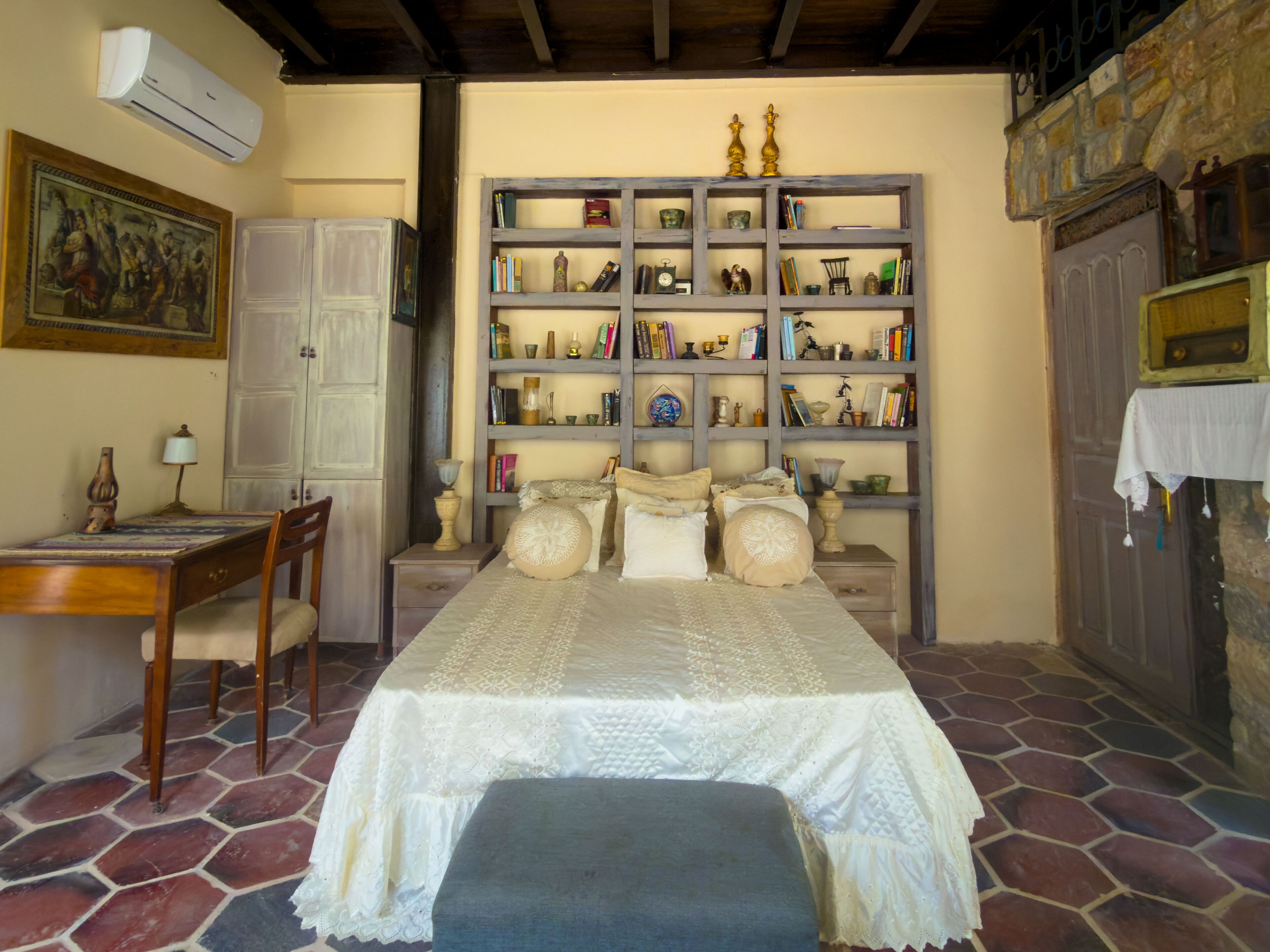 A bedroom with a bed, a desk, a chair, a bookshelf, and a wardrobe.