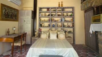 A bedroom with a bed, a desk, a chair, a bookshelf, and a wardrobe.
