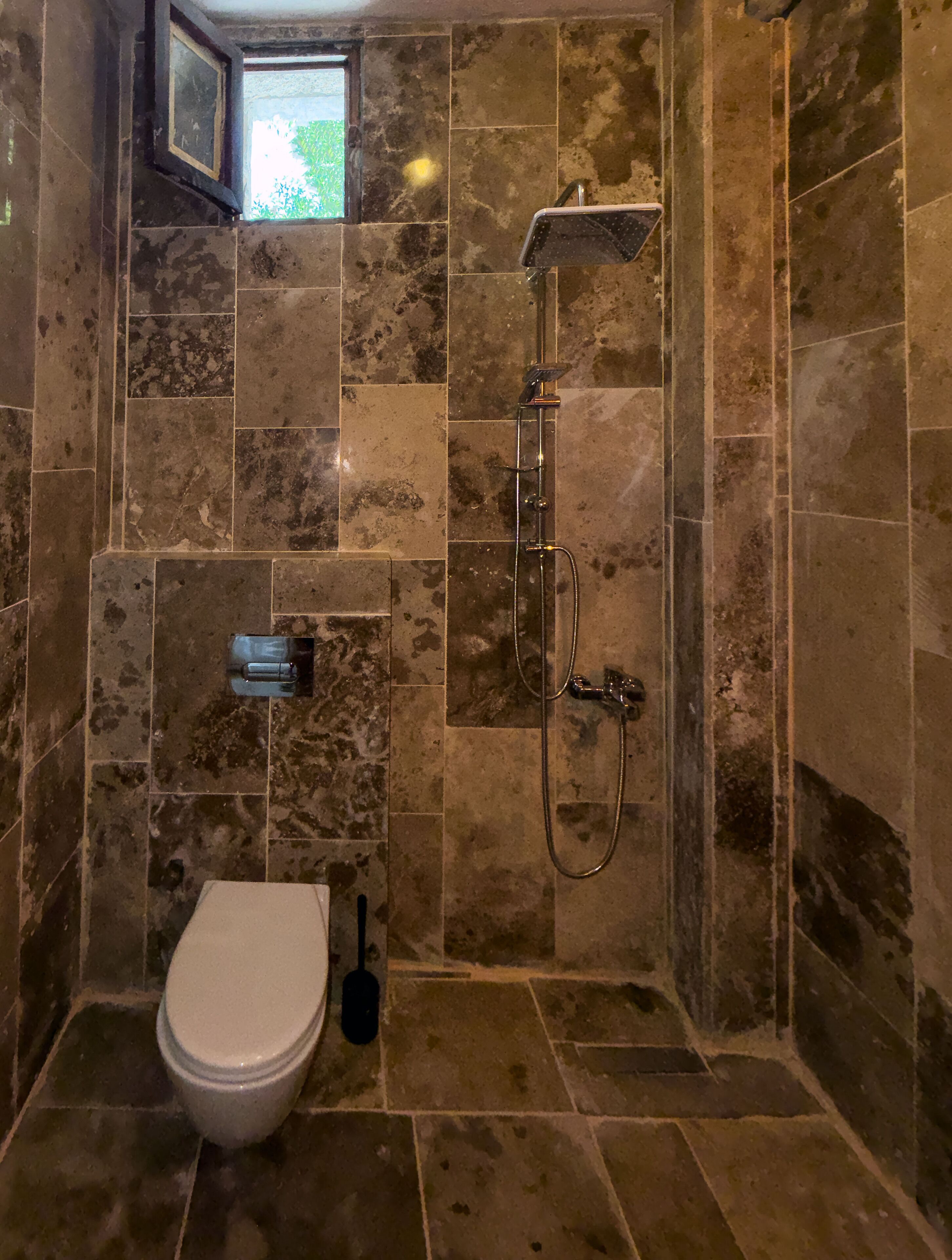 A bathroom with a toilet, a bidet, and a shower.
