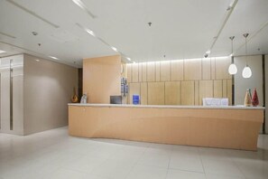 Ein Empfangsschalter mit modernem Design, eine Wanduhr und ein aufgeräumtes, minimalistisches Interieur.