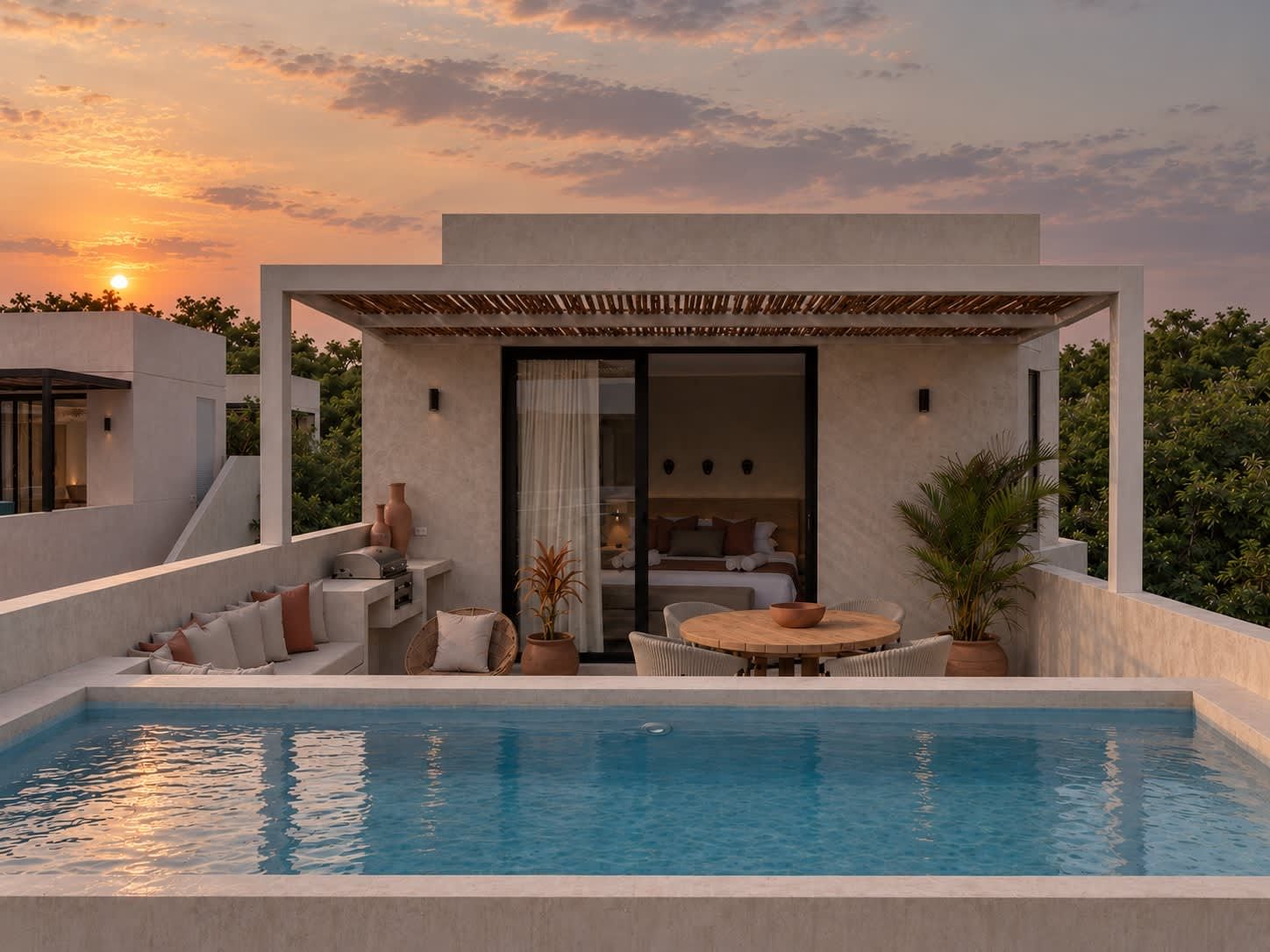 A modern outdoor pool area with a seating arrangement and a view of the sunset.