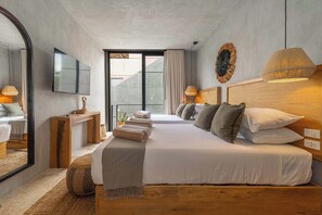 Ein modernes Hotelzimmer mit einem großen Bett, einem Fernseher, einem hölzernen Kopfteil und Blick ins Freie.
