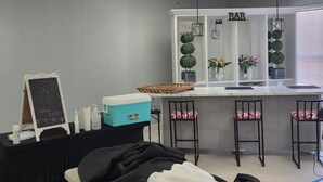 A bar area with a counter, stools, and decorative plants.