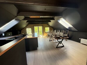 En moderne loftlejlighed med et køkkenområde, et spisebord med stole og ovenlysvinduer.