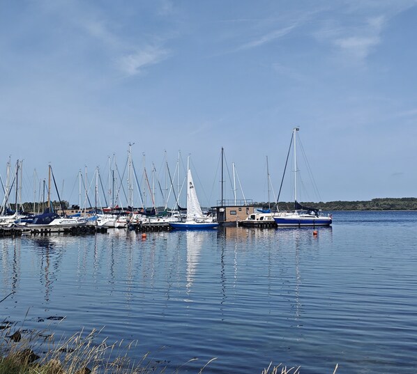 A marina with multiple sailboats docked, calm water, and a clear sky. - Modern 4-person chalet in Zeeland—near the beach, Veere, Middelburg, and Domburg (Serooskerke)