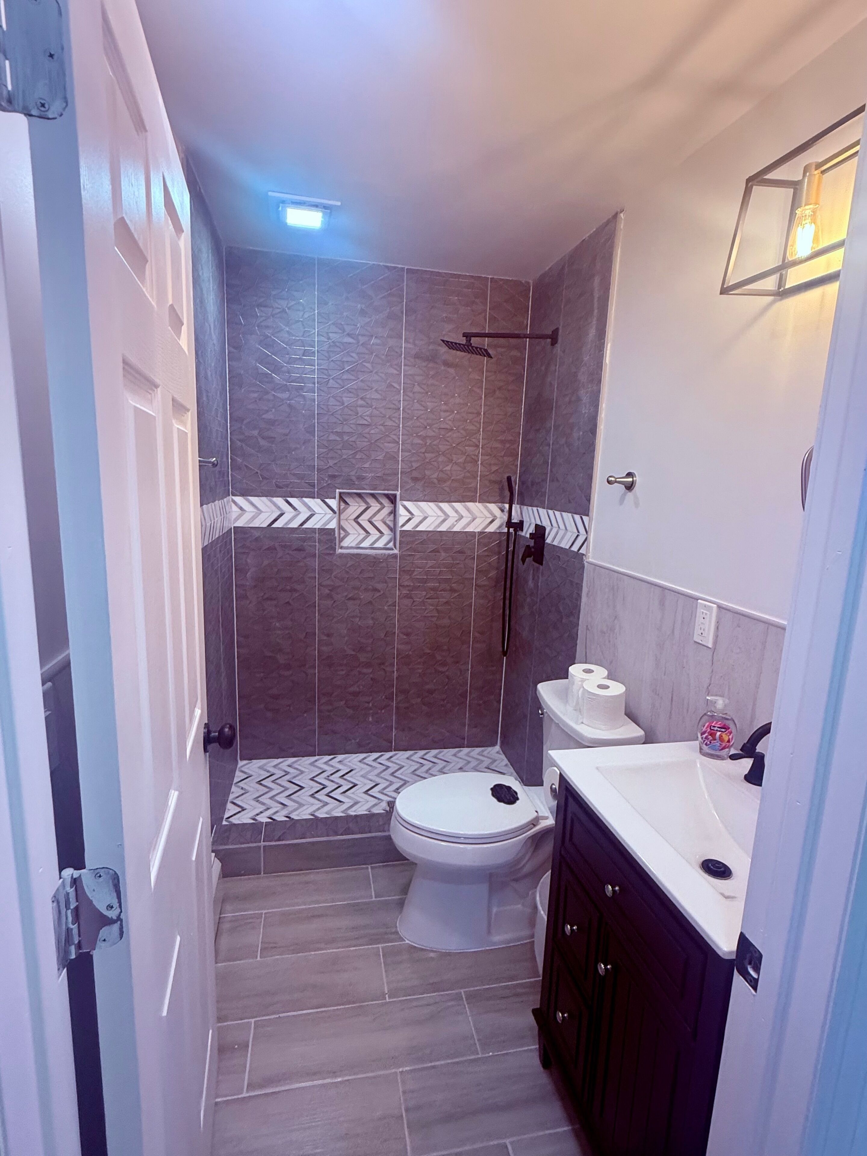 Un baño con ducha, inodoro y lavamanos.