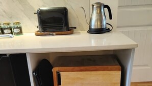 A kitchen with a toaster, kettle, and jars on the counter. - Victoria Garden Suite (Victoria)