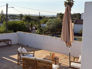 A rooftop terrace with wooden furniture, a table, and an umbrella. - NEW- LvPremier Algarve AB1 (Luz de Tavira)