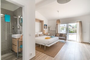 A modern bedroom with a large bed, a bedside table, a chair, and a view of the outside. - Accessible Algarve Villa with Private Pool, Brand-New Jacuzzi & Ocean ViewsLvPremier Algarve AB1 (Luz de Tavira)