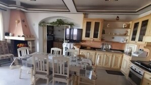 A kitchen with a dining area, tiled floor, wooden cabinets, and a built-in oven. - Vacation home in the center of Salento, a few km from the most beautiful beaches of Salento (Matino)