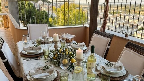 A table set for dining with a view of a cityscape and greenery. - Vacation home in the center of Salento, a few km from the most beautiful beaches of Salento (Matino)