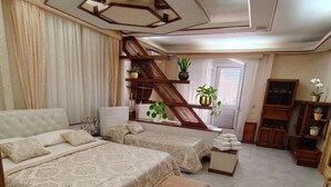 A spacious bedroom with a large bed, a smaller bed, a sofa, a chair, and a wooden staircase. - Vacation home in the center of Salento, a few km from the most beautiful beaches of Salento (Matino)