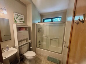 A bathroom with a toilet, sink, and glass-enclosed shower.